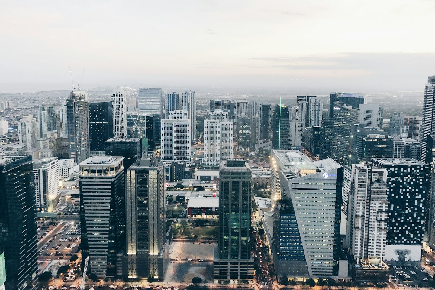 Modern cityscape with illuminated skyscrapers at dusk.