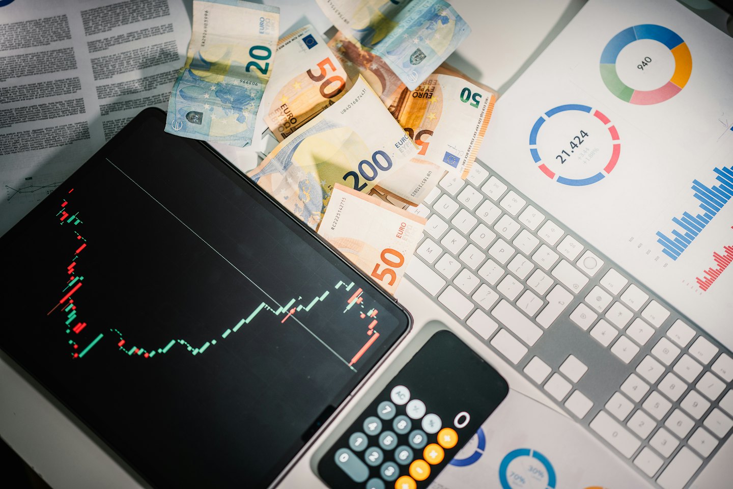 Euro banknotes and stock market chart on a business desk.